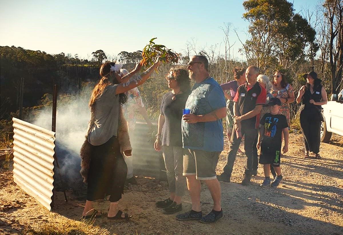 Auntie Sharon and Auntie Helen Riley perform a healing ceremony for residents a year after the Gospers Mountain bushfire devastated the community. 