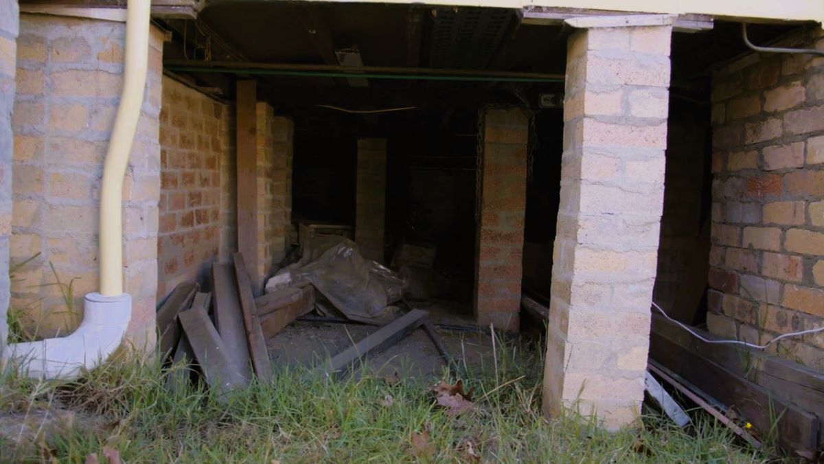 Storing combustible material under the house can assist fire. This image also shows exposed wooden rafters that could be ignited by embers.